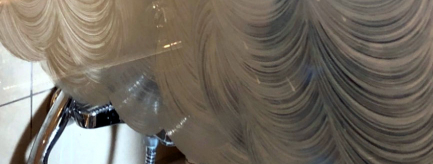 Foto einer Duschabtrennung aus Glas mit Streifen aus Reiniger darauf